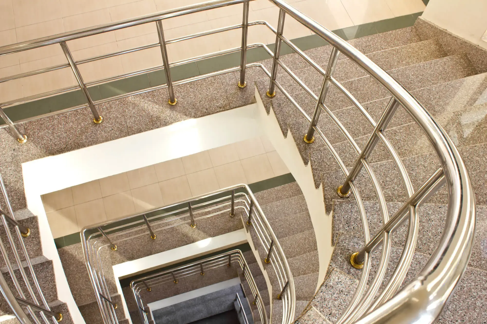 Escalera de mármol con pasamanos de acero inoxidable, ideal para la instalación de un salvaescaleras en Málaga.