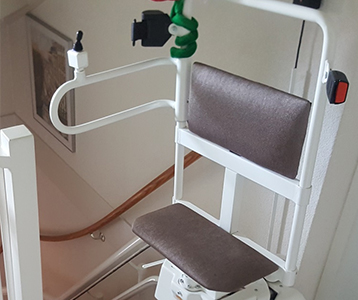 Salvaescaleras de apoyo con asiento abatible y estructura compacta, perfecto para escaleras estrechas en Málaga.