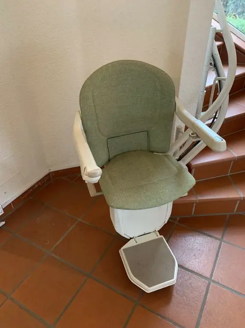 Asiento acolchado verde del salvaescaleras Lifta 6100, ideal para escaleras estrechas